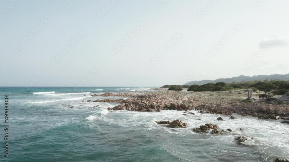 Aerial view drone over beach sea and rock coast with powerful sea waves. Beach sand and amazing sea in summer. Sardinia, Italy