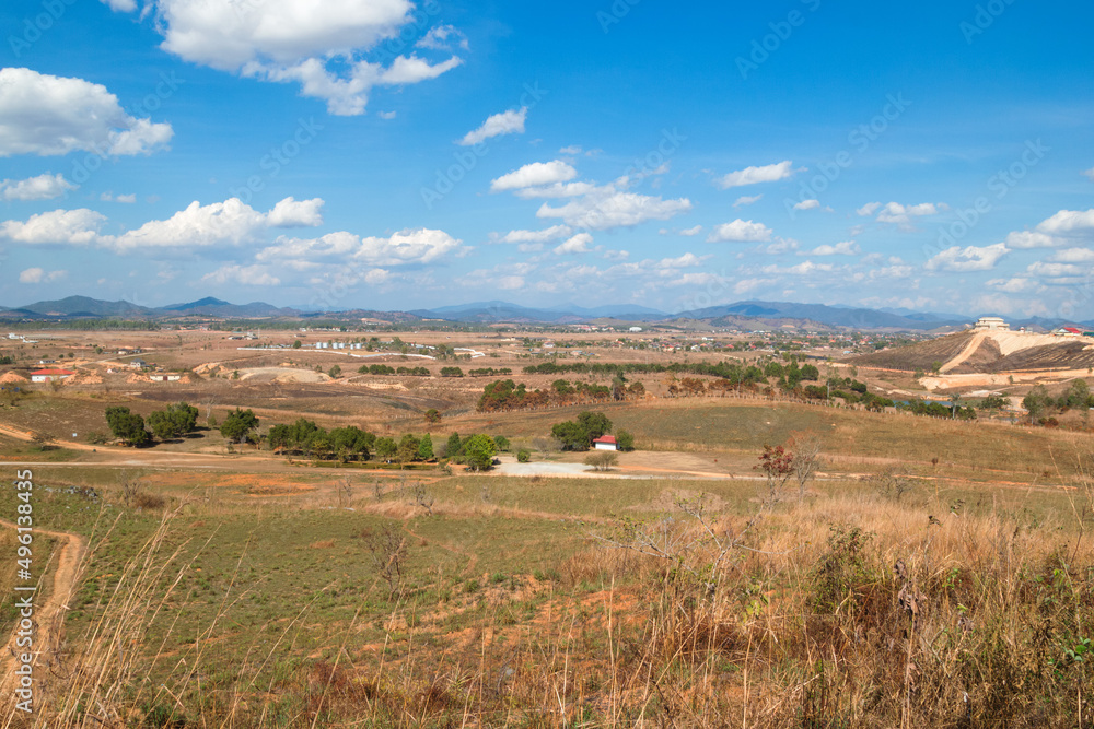 Rural landscape with mountains, fields, village on background of blue cloudy sky. Phonsovan, Laos. Rural landscape with mountains, fields, village on background of blue cloudy sky. Phonsovan, Laos.