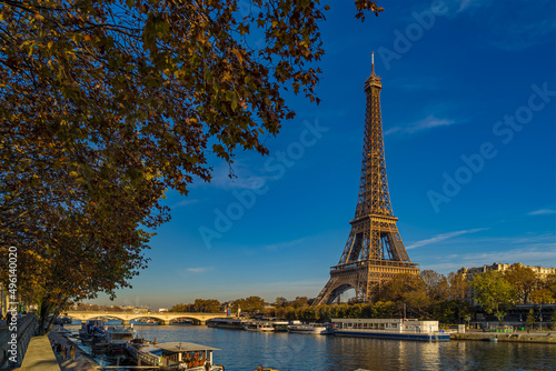 Eiffel Tower Enlightened by Sun at Day in Paris Fall Colors Trees Seine River and Boat Cruises © Loic Timelapse