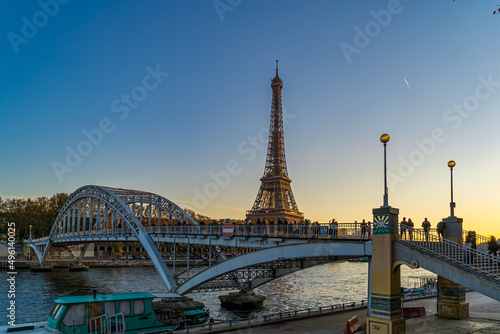 Eiffel Tower Overlooking a Pedestrian Bridge With Tourists Enjoying the View at Golden Hour