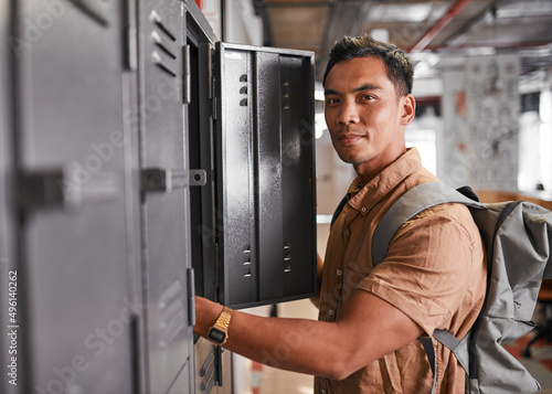 Fotografía A young Filipino man reaches inside his university locker on campus