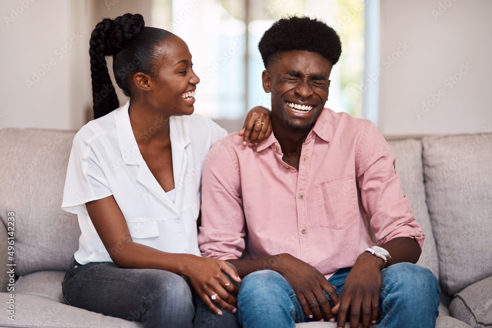 Stop laughing its not funny. Shot of a happy young couple relaxing on the sofa at home. Stop laughing its not funny. Shot of a happy young couple relaxing on the sofa at home.