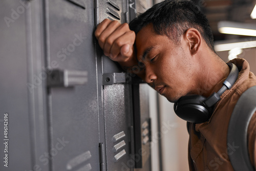 A student leans against campus lockers after getting bad news photo