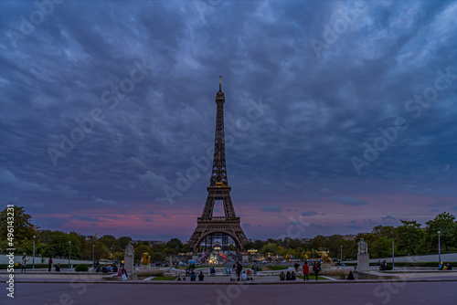 Purple Sky at Evening Over Eiffel Tower With Tourists Denses Clouds and Trees