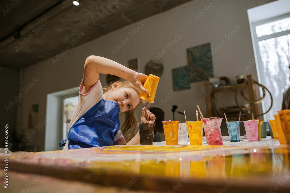 Creative child experimenting with paints to mix with each other Creative child experimenting with paints to mix with each other