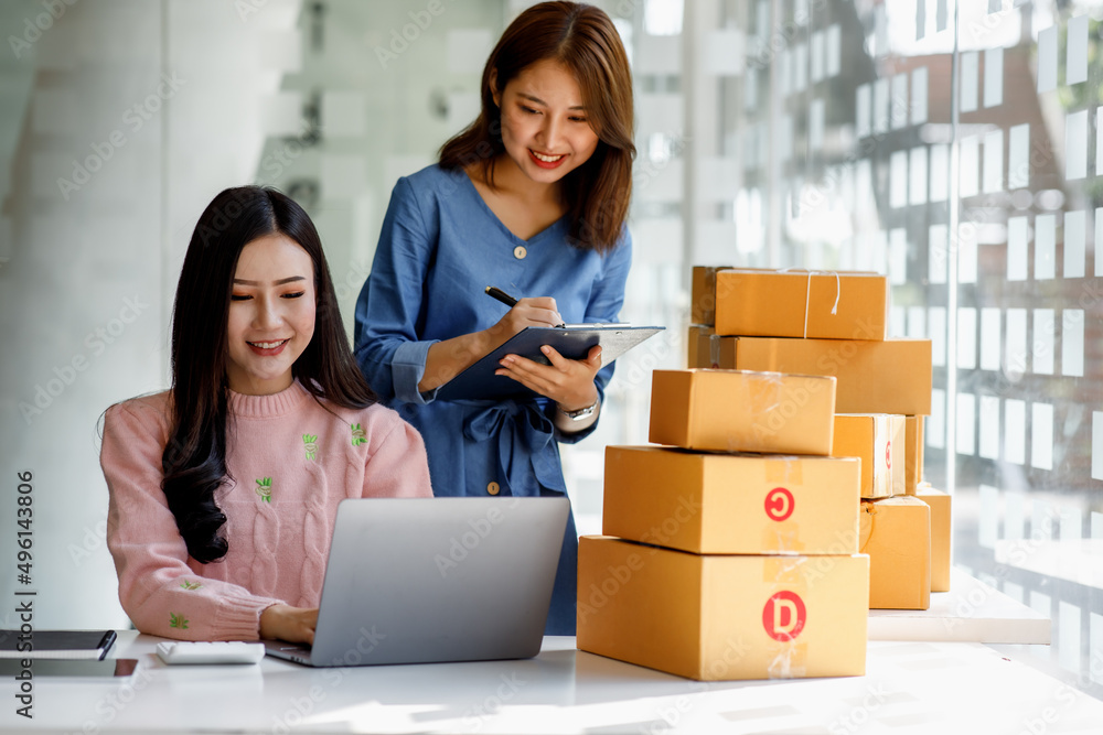 Portrait of Starting small businesses SME owners, two Asian woman check online orders Selling products working with boxs freelance work at home office, sme business online small medium enterprise Portrait of Starting small businesses SME owners, two Asian woman check online orders Selling products working with boxs freelance work at home office, sme business online small medium enterprise