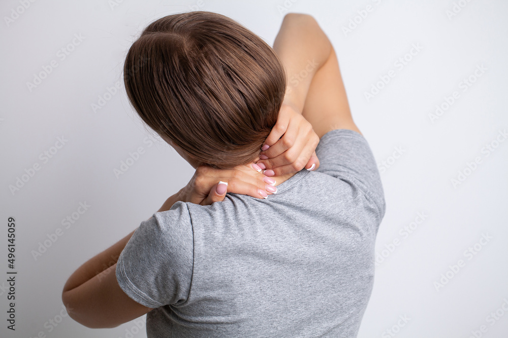 Young moody young woman holding her neck Young moody young woman holding her neck