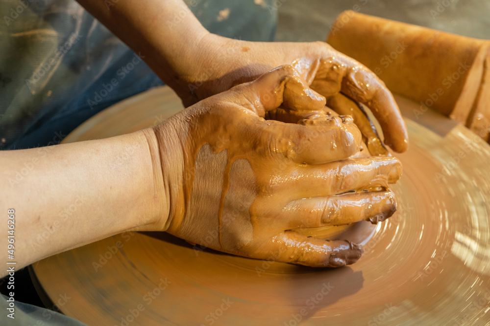 Work with clay. Hands of a potter close-up. The potter works on the potter's wheel