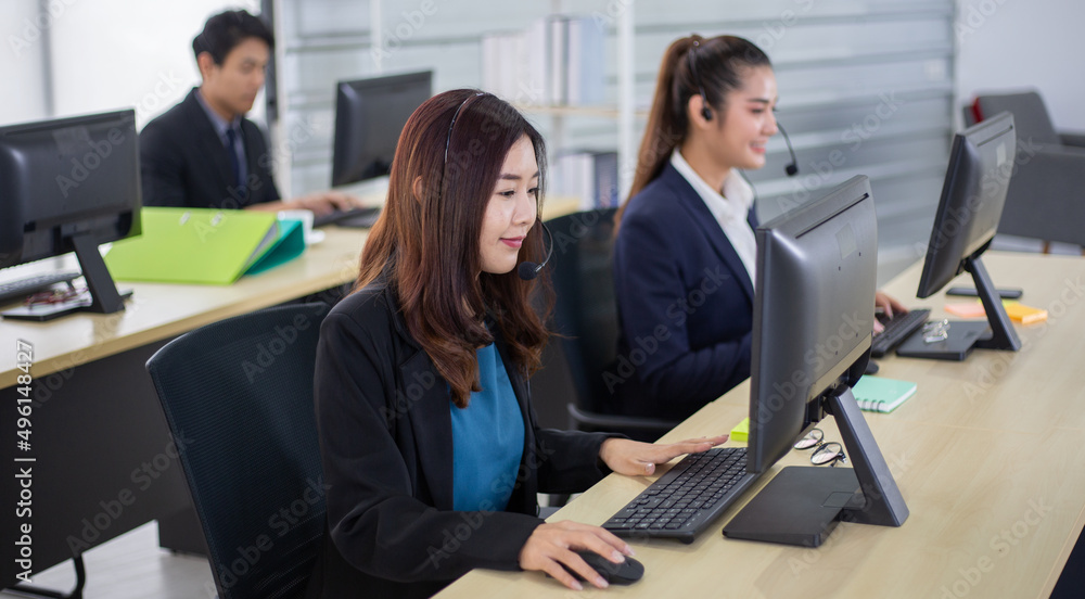 Young Asian business call center man and woman with headset sitting in office desk using computer. work for telemarketing. consulting service or customer support. operator agent giving advice on phone Young Asian business call center man and woman with headset sitting in office desk using computer. work for telemarketing. consulting service or customer support. operator agent giving advice on phone