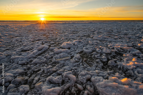 Close-up of snow and ice on sea shore at winter. Sunset sky. © Aleks Kend