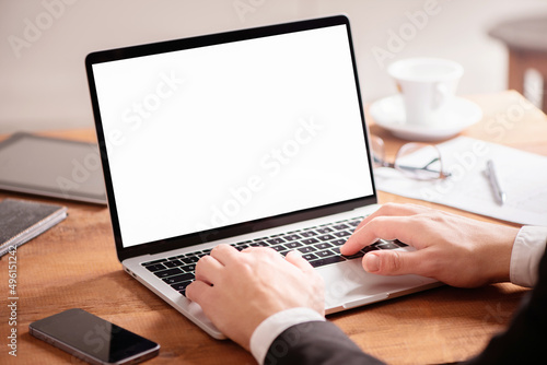 Cropped photo of young businessman using laptop on wooden table