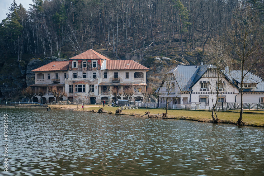 Fototapeta premium Vysoka Bosyne, Czech Republic, 19 March 2022: Former hotel and house of Harabistro, formation and protected landscape area in Kokorinsko, sandstone cliffs, lake Harasov at sunny day, rocks and hills