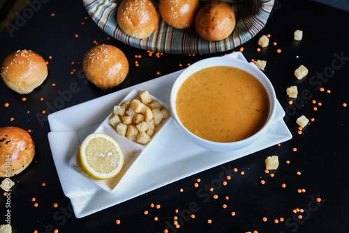 lentil soup, delicious lentil cream-soup with lemon and small pieces of twice-baked bread, rusk photo