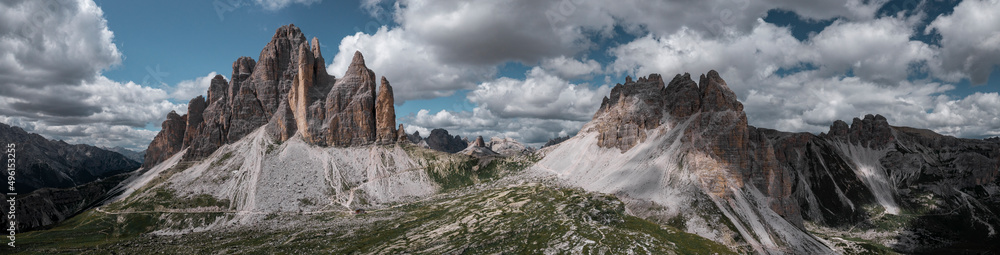 Mountain panorama with Three Peaks mountain summits and Paternkofel in the Dolomite Alps in South Tyrol with clouds in blue sky.