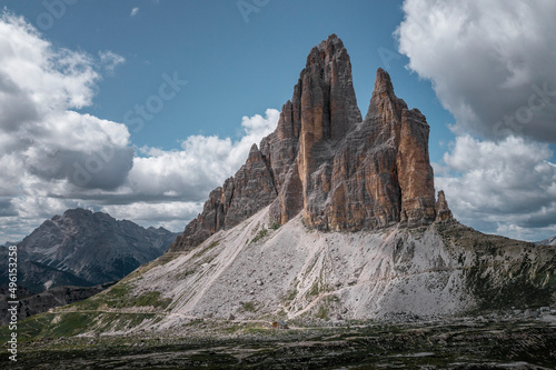 Mountain panorama with Three Peaks mountain summits in the Dolomite Alps in South Tyrol with clouds in blue sky.