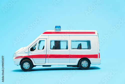 A white toy ambulance with red lines on a blue background. Special transport, toy store.