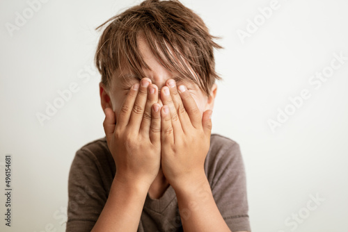 boy covering his face with hands