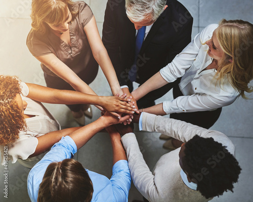 Get involved, get it done. High angle shot of a group of colleagues joining their hands in solidarity.
