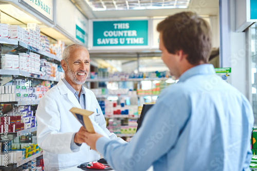 He knows what his customers need. Cropped shot of a handsome mature male pharmacist helping a customer in the pharmacy.