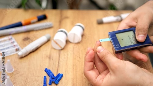 Man hands using lancet on finger to check blood sugar level by glucose meter, healthcare medical and diabetes concept.