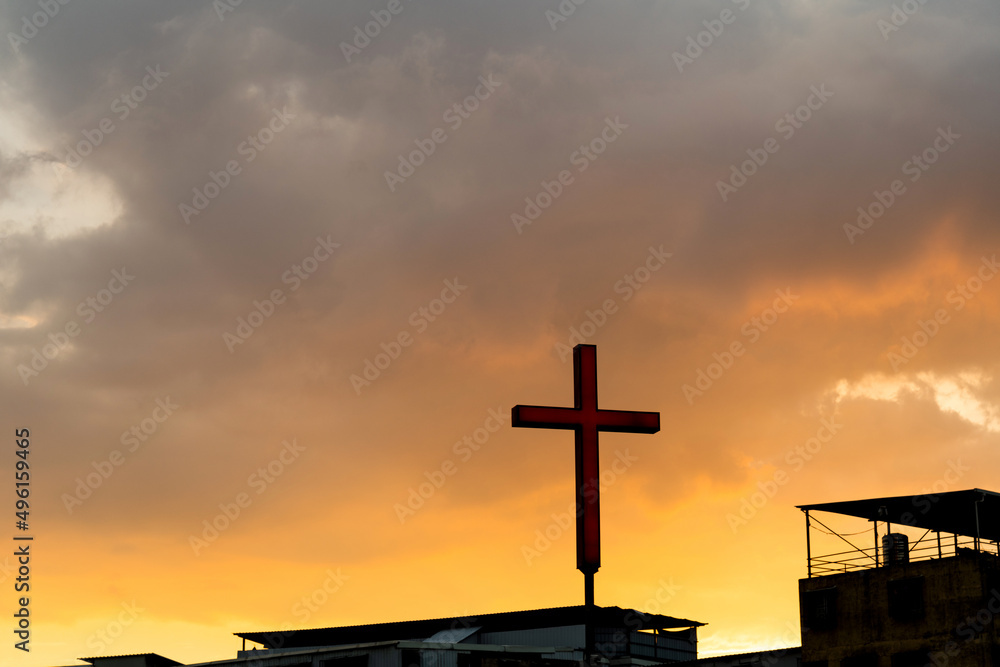 Countryside church with cross under sunset