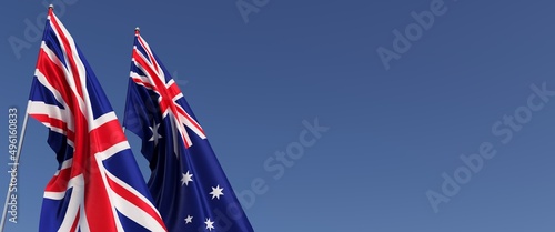 Flags of the United Kingdom and Australia on flagpoles on side. Flags on a blue background. Great Britain, England. Canberra, Melbourne. 3D illustration.