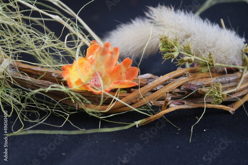 Ostermotive auf schwarzem Hintergrund. Osterdekorationen in Nahaufnahme. Weidenkranz mit bunten Eiern. Arrangement in Eierschale auf Stroh. Tonei mit Huhn darin. Symbole des Lebens und des Glücks.