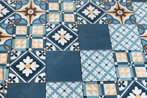 Blue and white tiles with flowers and yellow shapes and patterns.