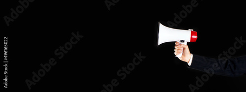 Fotografia Businessman holding megaphone on empty black background