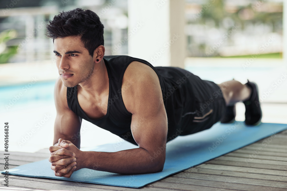 Push yourself, no one else will. Shot of a young man planking during his workout at home.