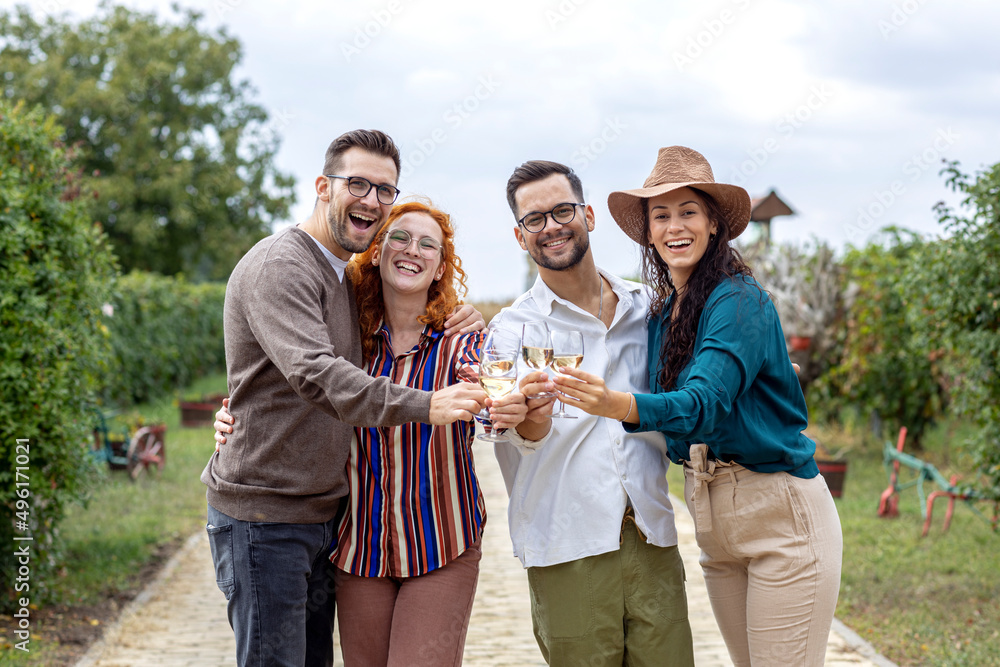 Four friends standing in vineyard with glasses of vine red and white drinking, relaxing and talk to each other in summer day. Four friends standing in vineyard with glasses of vine red and white drinking, relaxing and talk to each other in summer day.