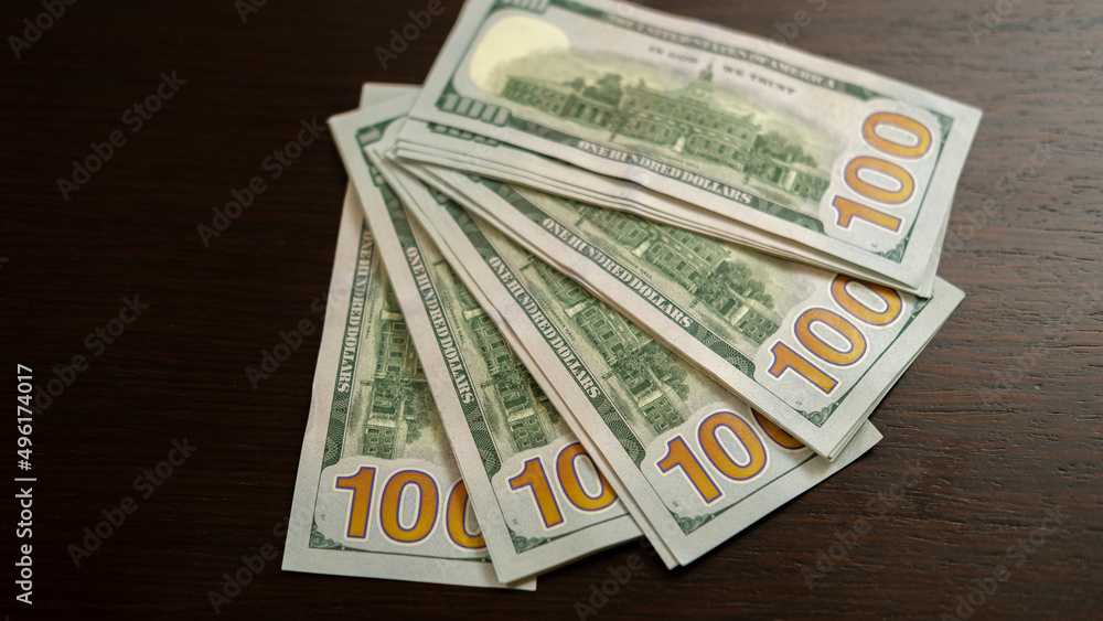 A sheet of new hundred dollar bills are laid out on the table, in a row and in a circle. Great background for filling. A sheet of new hundred dollar bills are laid out on the table, in a row and in a circle. Great background for filling.
