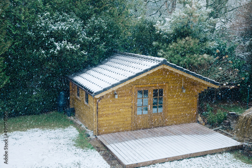Nice wooden hut in a garden with snow. Garden shed with chairs in winter. Winter mood. Drinking tea outside by cold in winter.  snow in Germany. garden in winter. holiday house