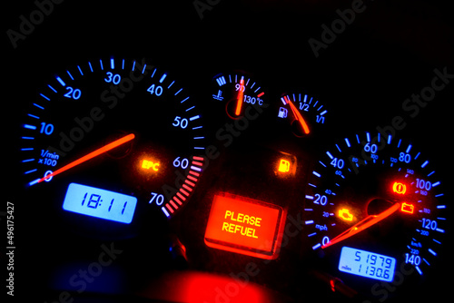 car dashboard showing refuel light illuminated.