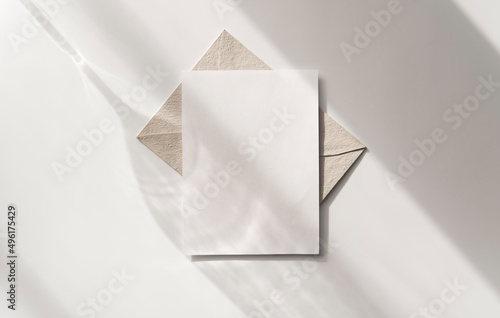 Mockup blank greeting card. Composition with shadows from a glass goblet on white background. 