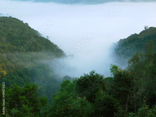 Landscape of the mist covered Mountain in the morning with warmed sun beams for background wallpaper