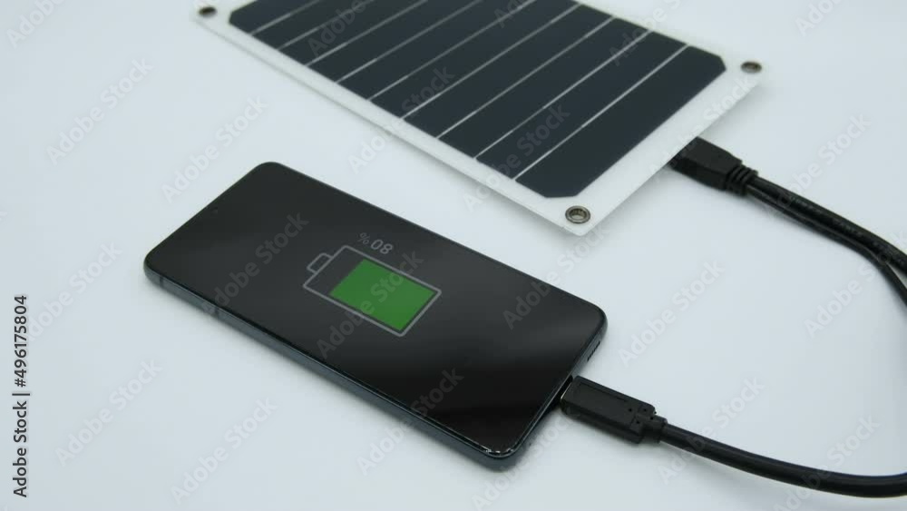 View of smartphone charging using portable solar photovoltaic panel,renewable green energy tech View of smartphone charging using portable solar photovoltaic panel,renewable green energy tech