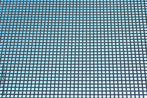 blue background, in the photo a metal grid with square cells on a blue background.