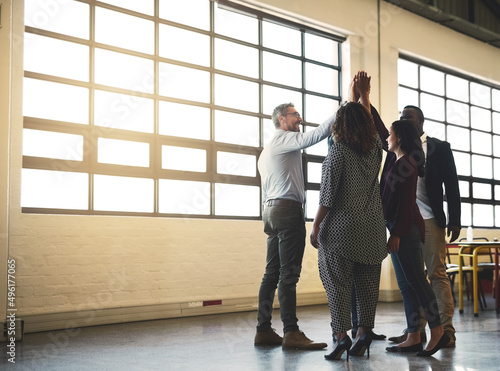 We feel good about the work we do. Shot of a diverse team of happy businesspeople high fiving each other in the office.