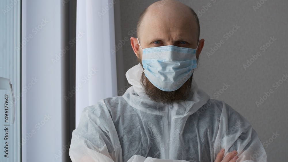 The face of a male doctor in a rest room in a mask, a paramedic looks into the frame, a man with a beard and a bald head. The work of doctors to save people from a pandemic. The face of a male doctor in a rest room in a mask, a paramedic looks into the frame, a man with a beard and a bald head. The work of doctors to save people from a pandemic.