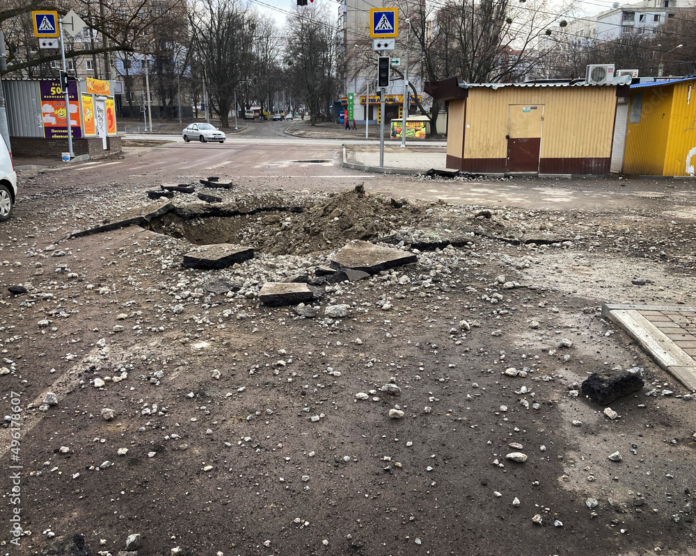Kharkiv Ukraine 2022 Destruction in the city after the Russian attack. Destroyed infrastructure of the city. A shell crater in the courtyard of the city. - obrazy, fototapety, plakaty 