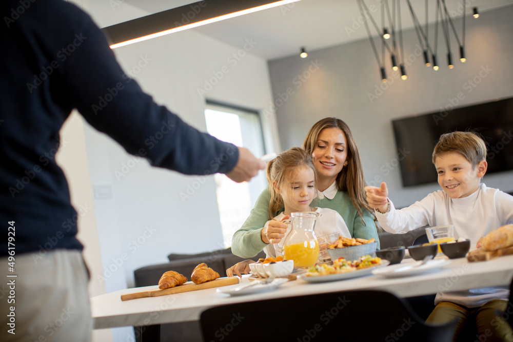Young happy family talking while having breakfast at dining table Young happy family talking while having breakfast at dining table