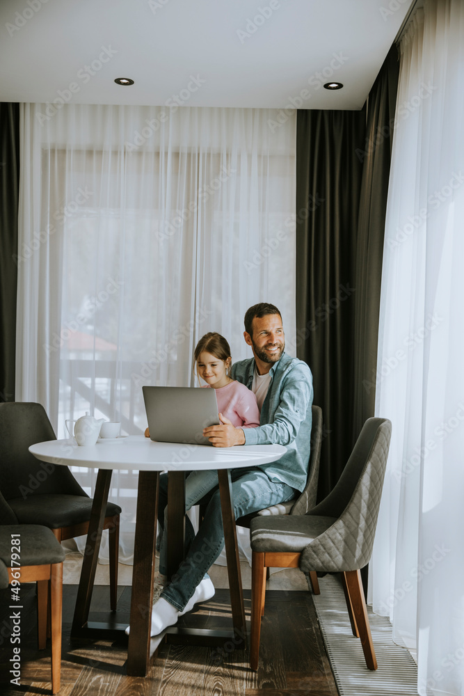 Father and daughter using laptop computer together
