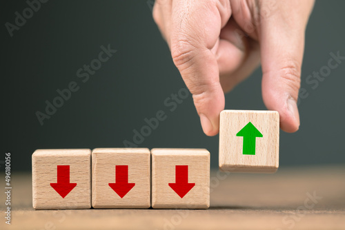 Closeup hand pick the wood cube in a row, turn the red arrow symbol into green color, change things better, business and investment, trend to improve and get better at the end of the row
