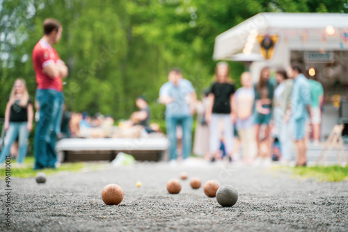 Friends playing petanque guy throwing a ball outdoor city park	
