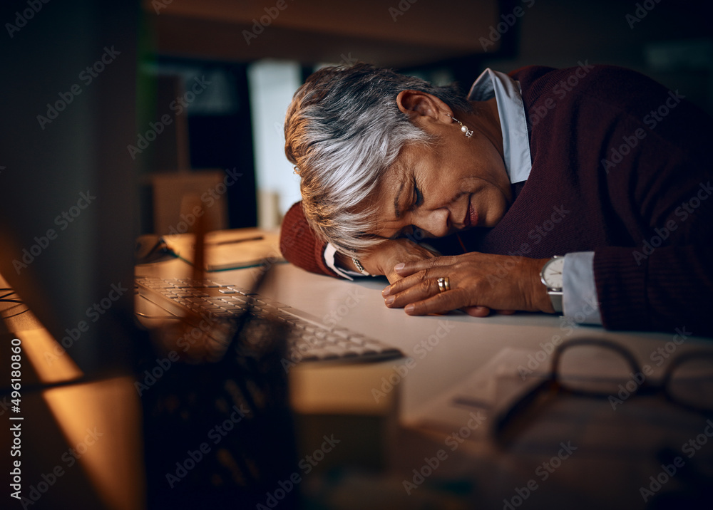 I just need a quick snooze.... Shot of a mature businesswoman sleeping at her desk while working late in an office. I just need a quick snooze.... Shot of a mature businesswoman sleeping at her desk while working late in an office.