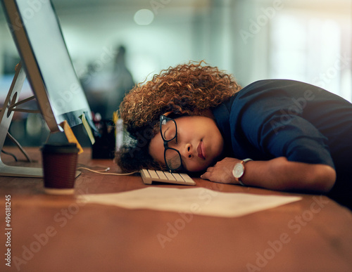 Game over. Shot of an exhausted young businesswoman sleeping at her desk during a late night at work.