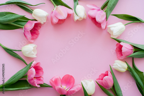Fototapeta Naklejka Na Ścianę i Meble -  top view of frame with blooming flowers on pink.
