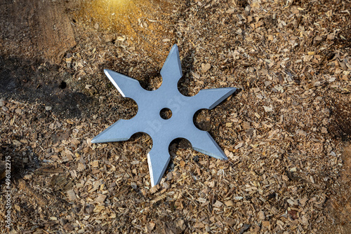 Shuriken (throwing star), traditional japanese ninja cold weapon stuck in wooden background