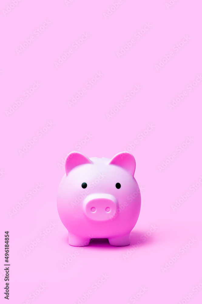 Pink color piggy bank on pink color background.